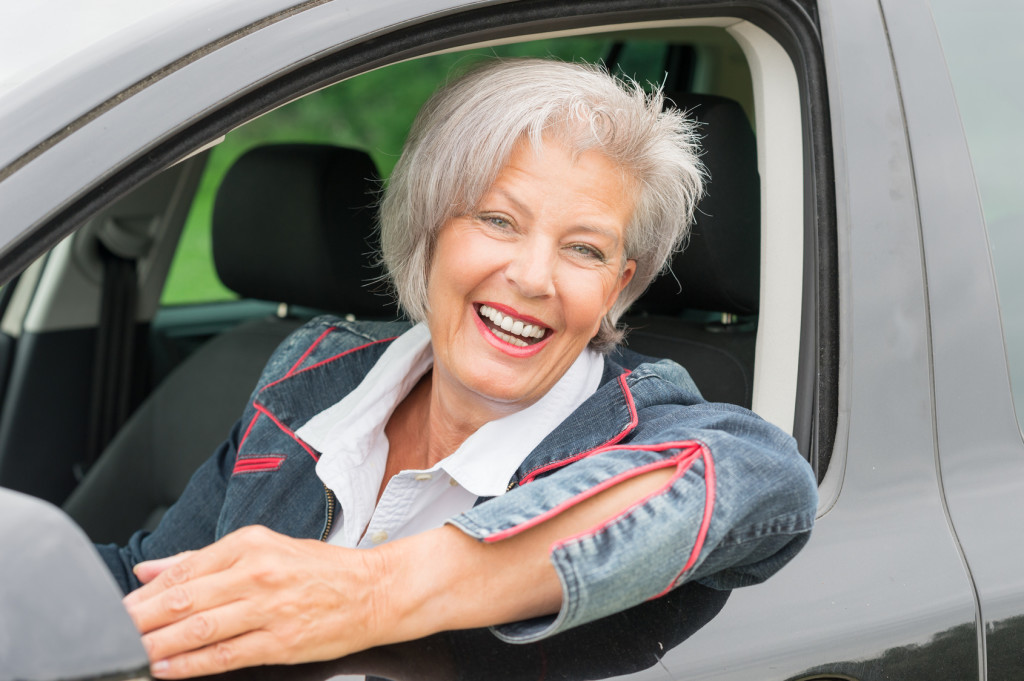 Happy and smiling senior woman in private driving school